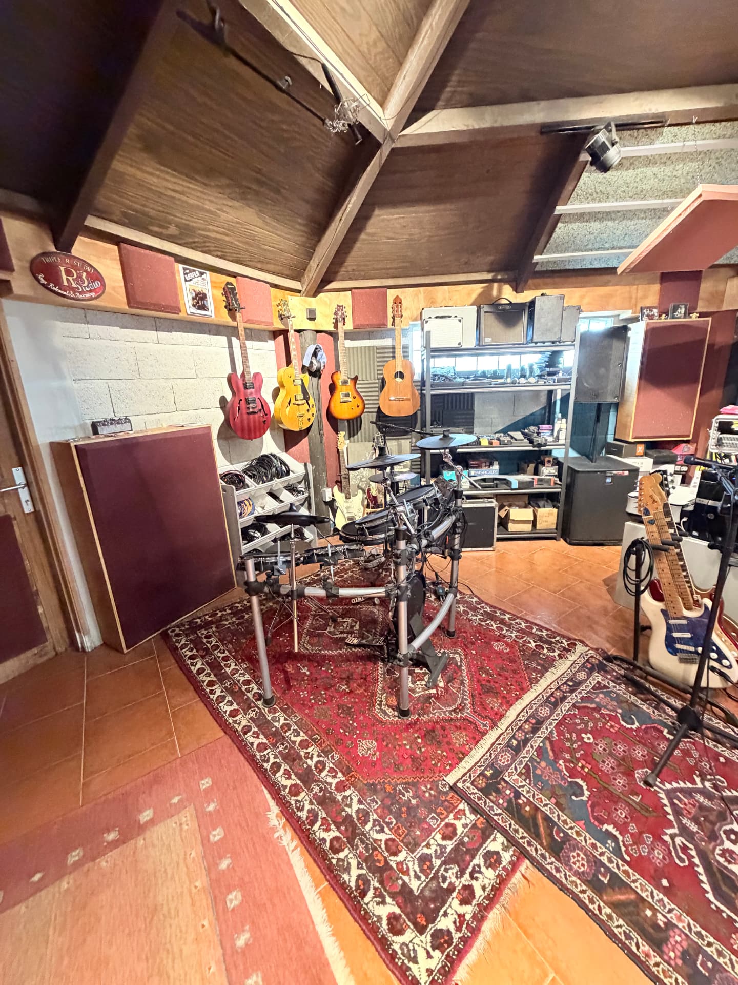 Rehearsal room with drum kit and guitars on the wall